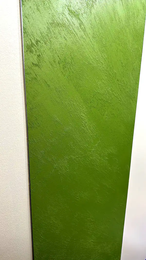 Grüne Wandfläche mit strukturierter, glänzender Oberfläche