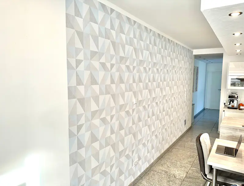 Lange Wand mit weißer Tapete im Dreiecksmuster